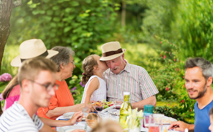 Picture of a happy family, a picnic with a granddaughter, kissing her grandfather on the cheek