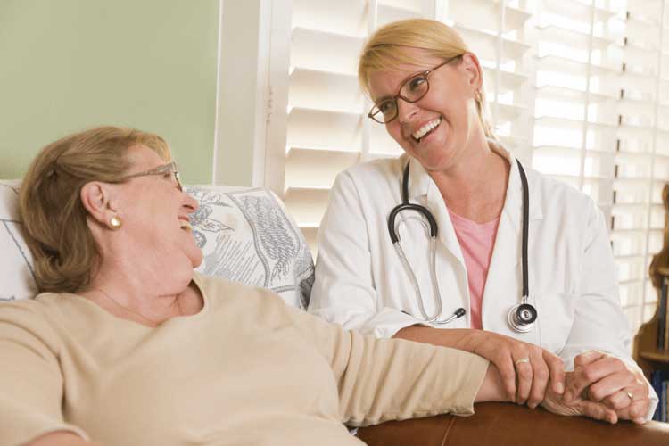 Doctor looking fondly at her patient who is sitting in a chair